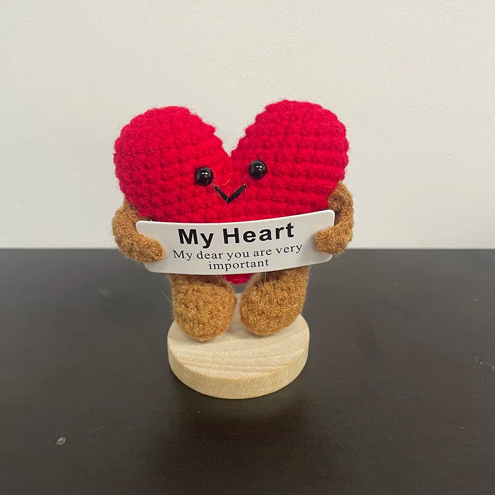 Handmade crochet heart plush doll in bright red with brown legs and arms, holding a sign that says "My Heart β My dear you are very important